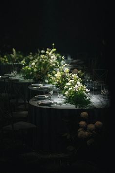 the table is set up with flowers and wine glasses on it for an elegant dinner