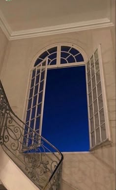 a staircase leading up to a window with a blue sky in the backround