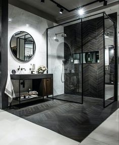 a bathroom with a walk in shower next to a sink and mirror on the wall