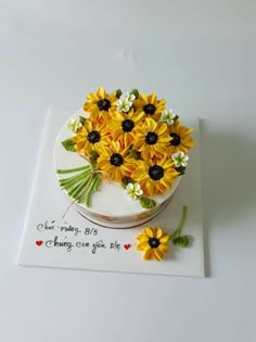 a cake decorated with sunflowers and daisies