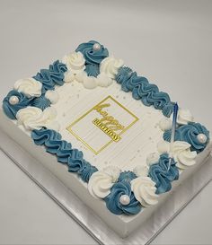 a square cake decorated with blue and white icing