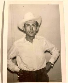an old black and white photo of a man in a cowboy hat standing with his hands on his hips