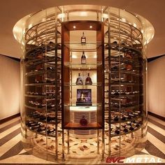 a wine cellar in the middle of a room with shelves filled with bottles and glasses