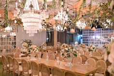 a dining room set up with chandeliers and flowers