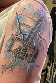 a man with a tattoo on his arm has a hammer and lightning bolt in it