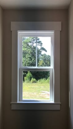 an empty room with a large window in the corner and no curtains on the windowsill