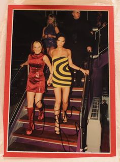 two women in short dresses are walking down the stairs