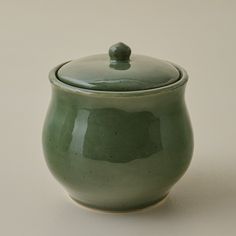 a green ceramic jar with a lid