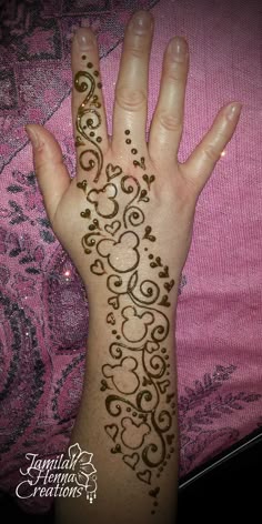 a woman's hand with henna tattoos on her left arm and the top half of