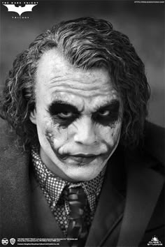 a man dressed as the joker with his face painted black and white, wearing a suit