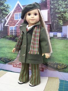 the doll is wearing a green coat and plaid pants