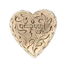 a gold heart shaped brooch with the word love in arabic writing on it's side