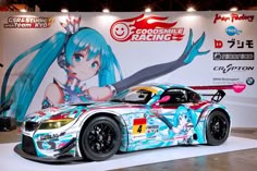 a car is on display in front of a large advertisement for an upcoming racing game