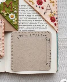 an open book that has various pieces of fabric on it