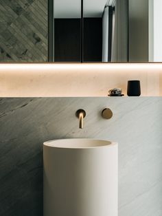 a white sink sitting under a mirror in a bathroom next to a wall mounted faucet