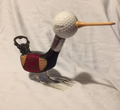 a golf ball on top of a metal bird