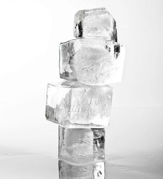 three ice cubes stacked on top of each other in front of a white background