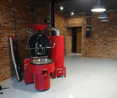 an industrial coffee machine sits in the middle of a large room with exposed brick walls