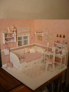a doll house with furniture and accessories on the table in front of the bed is made out of cardboard