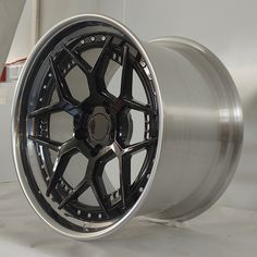 a close up of a wheel on a white surface with a black spoke and silver rim