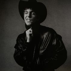 a black and white photo of a man wearing a cowboy hat
