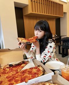 a woman sitting at a table with pizza in front of her