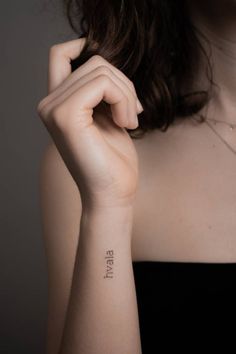 a woman with a small tattoo on her arm that reads, stay strong in cursive writing