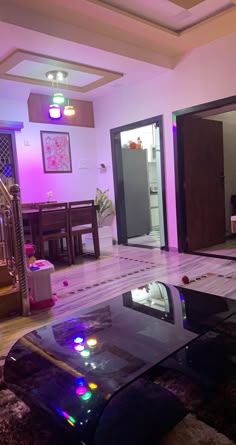 a living room filled with furniture and a glass table in front of a doorway that leads to another room