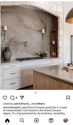 a kitchen with white cabinets and marble counter tops, an island in the middle is featured on instagram