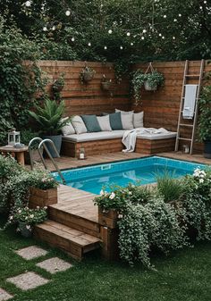 a small backyard with a pool surrounded by greenery and wooden steps leading up to it