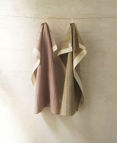 two folded towels hanging on the wall next to each other
