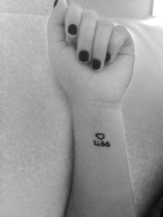 black and white photo of a woman's arm with the word love tattooed on it