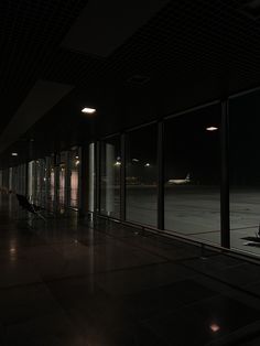 an empty airport terminal at night with the lights on and luggage bags in the foreground