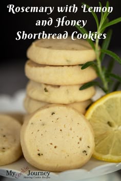 rosemary with lemon and honey shortbread cookies on a plate next to sliced lemons