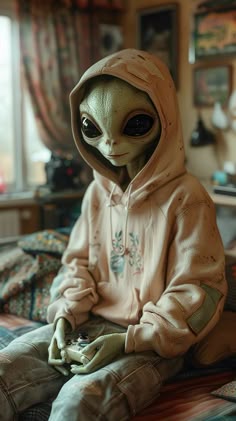 an alien sitting on top of a bed next to a person wearing a hoodie