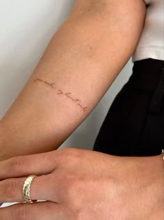 two people with their hands on each other's wrist, one has a small tattoo
