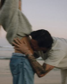 two people kissing each other on the beach