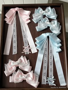 several different types of bows in a box on a table with white and blue ribbons