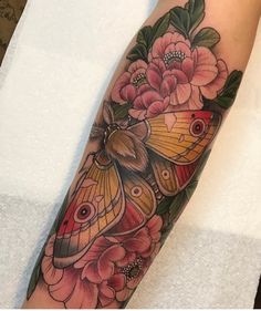 a butterfly and flowers tattoo on the left arm, with an instagramr above it
