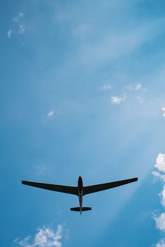 an airplane is flying in the sky on a clear day with blue skies and white clouds