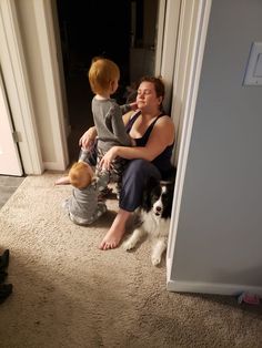 a woman sitting on the floor next to a child