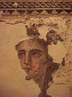 a close up of a painting on a wall with a woman's face in the middle