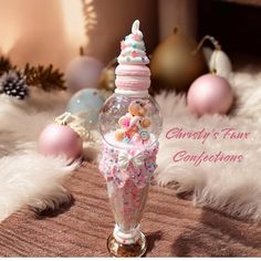 there is a glass bottle filled with pink and white confetti on the table