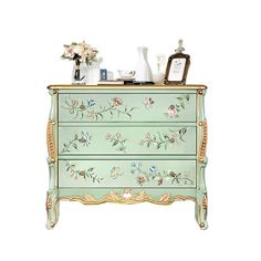 a green dresser with flowers painted on it