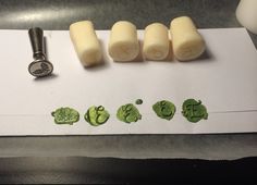 four pieces of wax sitting on top of a piece of paper next to a stamper