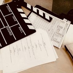 a black and white film clapper sitting on top of papers