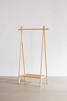 a wooden swing with two bars attached to the top and bottom, sitting on a concrete floor