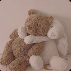 a brown teddy bear sitting on top of a white shelf
