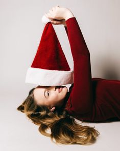a woman in a santa hat laying on her back with her arms behind her head
