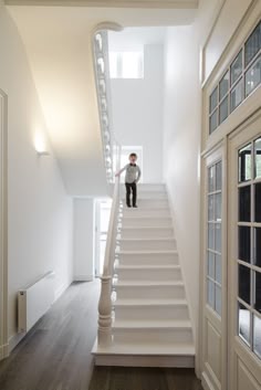 a little boy standing on the stairs in a house